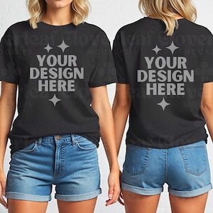 May include: Two women wearing black t-shirts with the text "YOUR DESIGN HERE" on the front and back. The shirts are a relaxed fit and have a crew neck. The women are wearing blue denim shorts.
