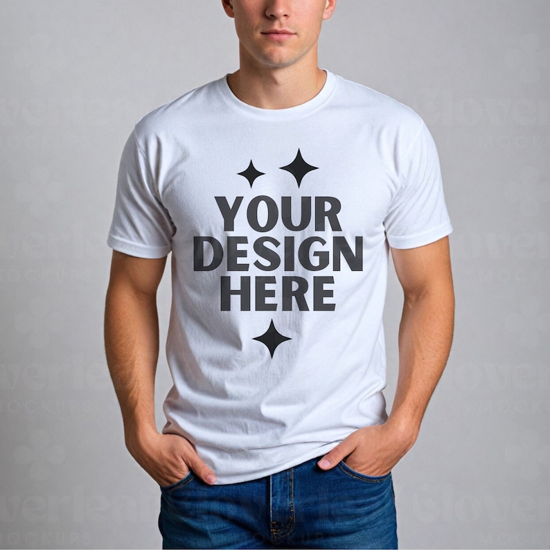 以下が含まれることがあります： 黒いデザインで「YOUR DESIGN HERE」と書かれた白いTシャツ。テキストの周りに小さな星が4つあります。