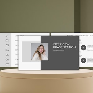 Puede incluir: Una diapositiva de presentación con fondo gris y texto blanco. El título de la presentación es "Interview Presentation" con el nombre del presentador, "Andrea Schiller", debajo. La diapositiva también incluye una lista de "Erfolgen & Meilensteine" con viñetas numeradas.