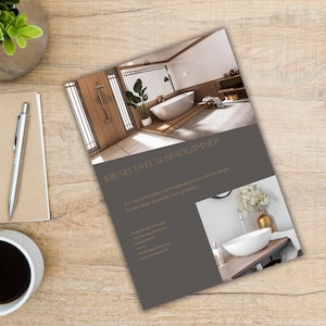以下が含まれることがあります： グレーの背景に金色の文字で「Ihr neues Luxusbadeszimmer」と書かれたパンフレット。パンフレットには、白いバスタブと木製の床のあるモダンなバスルームの写真が掲載されています。写真の下のテキストには、「Ein Traum für jeden Wellnessbegeisterten und ein Segen für die Seele: Entspannung und genießen.」と書いてあります。