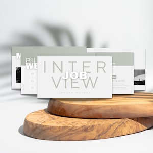 May include: A set of three grey cards with white text. The card in the centre reads "Interview Job View" with the text "Candor & Wagner" below. The card on the left has the text "Bill We" and the card on the right has the text "2024 Mercedes RD".