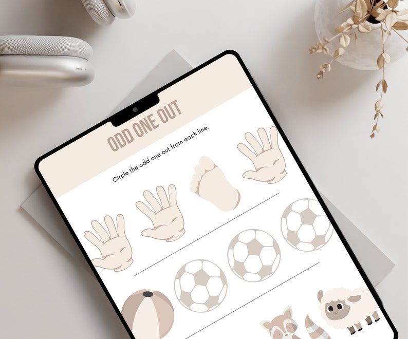 May include: A printable worksheet with the words "Odd One Out" and instructions to circle the odd one out from each line. The worksheet features three rows of images, including a hand, a foot, a football, a beach ball, a sheep, and a raccoon.