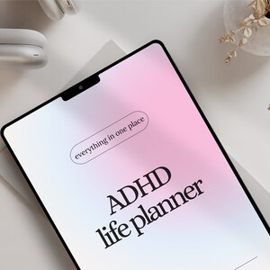 May include: A pink and blue digital planner with the text "ADHD life planner" and "everything in one place" on the screen.