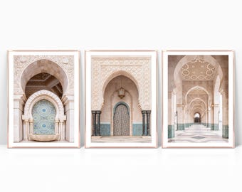 May include: A set of three prints featuring intricate archways and decorative details in a Moroccan style. The prints are in a light beige color with blue accents and are framed in a thin, rose gold frame.