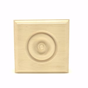 May include: A square, unfinished wooden decorative element with a raised circular design in the center. The wood has a light, natural color and a smooth finish. The design is a classic architectural detail.