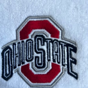 Könnte beinhalten: Gestickter Ohio State Logo-Patch in Rot, Schwarz und Grau auf weißem Hintergrund.
