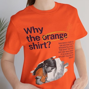 May include: Orange t-shirt with the text "Why the orange shirt?" and a graphic of a girl. The shirt also includes text about residential schools and lost culture. The shirt is a vibrant orange color.