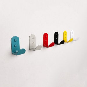 Puede incluir: Conjunto de seis ganchos de pared en varios colores, incluyendo azul verdoso, rojo, negro, amarillo y blanco. Cada gancho tiene una forma redondeada y un dise&ntilde;o simple.