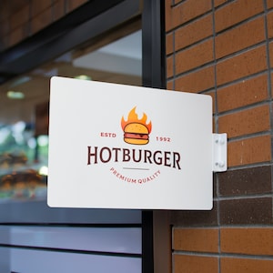 May include: White sign with red and orange logo for a restaurant called "Hotburger". The logo features a cartoon burger with flames and the text "ESTD 1992" and "Premium Quality".