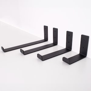 Puede incluir: Cuatro escuadras de estante de metal negro. Cada escuadra tiene un diseño en ángulo recto con un soporte horizontal plano y una placa de montaje vertical con agujeros pretaladrados. Adecuado para montaje en pared y diversas aplicaciones de estanterías.