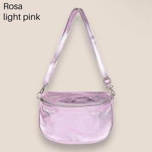 May include: A light pink metallic crossbody bag with a silver zipper and adjustable strap. Rosa light pink.