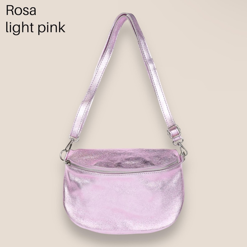May include: A light pink metallic crossbody bag with a silver zipper and adjustable strap. Rosa light pink.