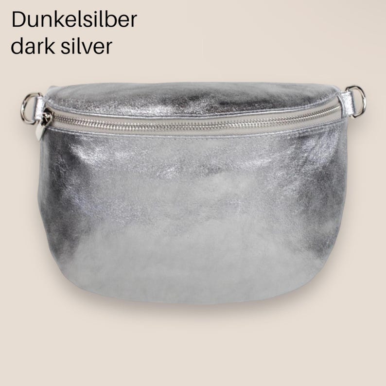 May include: A silver leather fanny pack with a zipper closure. The text "Dunkelsilber dark silver" is above the bag.