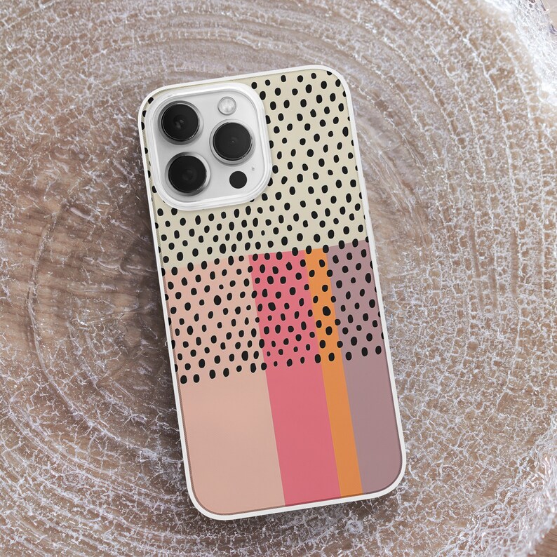 May include: A white phone case with a geometric pattern of black dots and stripes in pink, orange, and brown.