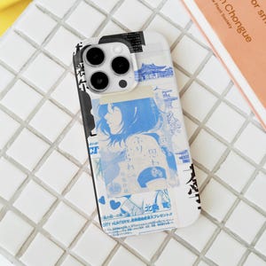 May include: A white phone case with a collage of blue and black Japanese-style illustrations. The design includes a woman's portrait, Japanese text, and architectural drawings. The case is designed to fit a smartphone.