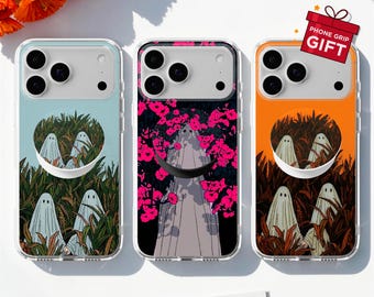 May include: Three clear phone cases featuring ghost illustrations. The left case has a light blue background with ghosts in a cornfield. The middle case shows a ghost among bright pink flowers. The right case has an orange background with ghosts in a cornfield. Each case includes a circular phone grip and a gift tag.