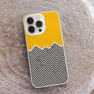 May include: A yellow and black phone case with a geometric chevron pattern. The case has a cutout for the camera lens.