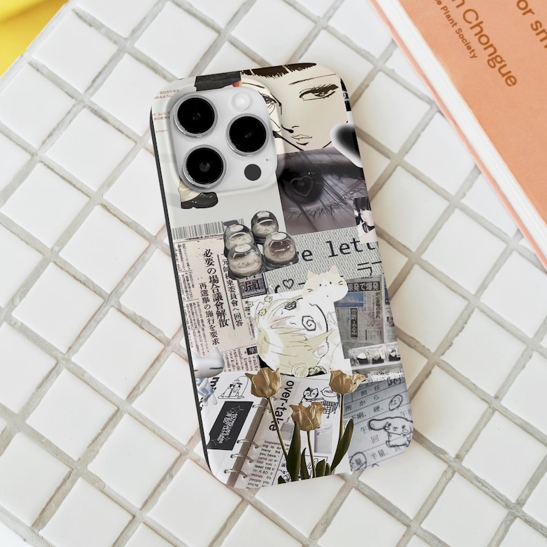 May include: A clear phone case featuring a collage of newspaper clippings, illustrations, and a cat design. The case includes a drawing of a woman's face, shoes, and text in Japanese. The case also has a floral design.