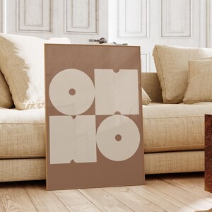 May include: A framed print with a geometric design in shades of brown and white. The print features four overlapping circles and squares, creating a modern and abstract look.