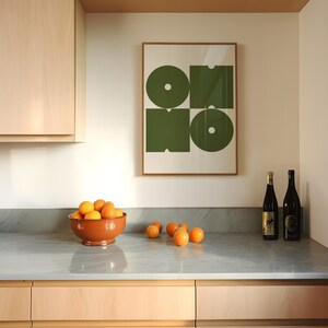 May include: A kitchen counter with a bowl of oranges, two bottles of wine, and a framed print with a green geometric design. The print has the word "ONO" in the center.