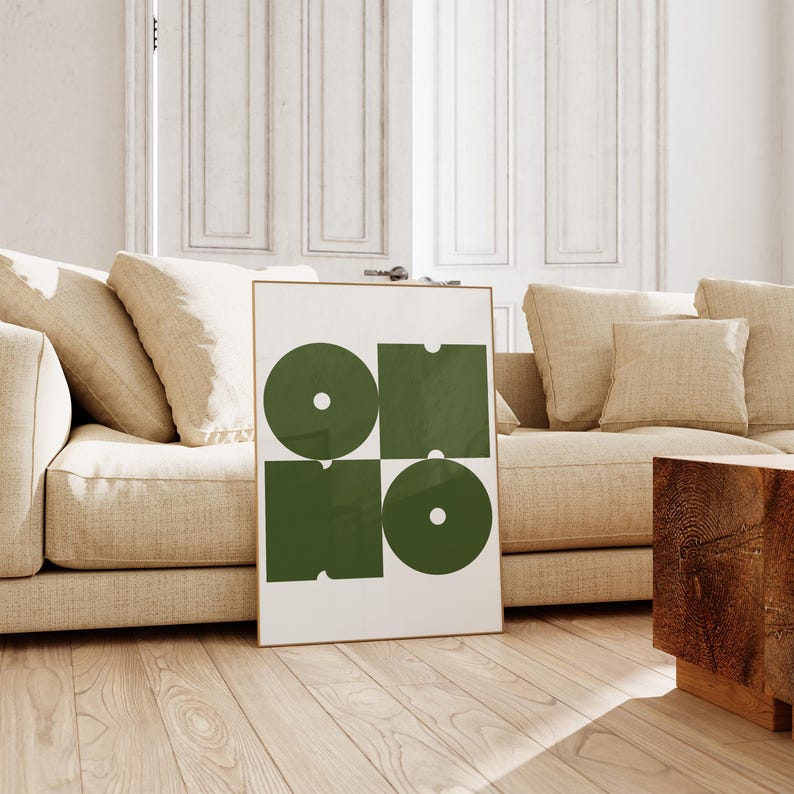 May include: A framed print with a geometric design featuring four green shapes, two circles and two squares, on a white background.