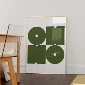 May include: A framed print with a geometric design featuring four overlapping circles and squares in a dark green color on a white background.