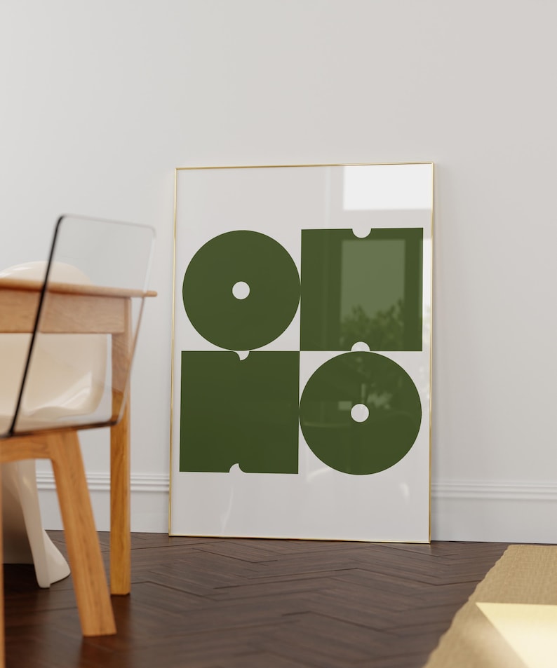 May include: A framed print with a geometric design featuring four overlapping circles and squares in a dark green color on a white background.