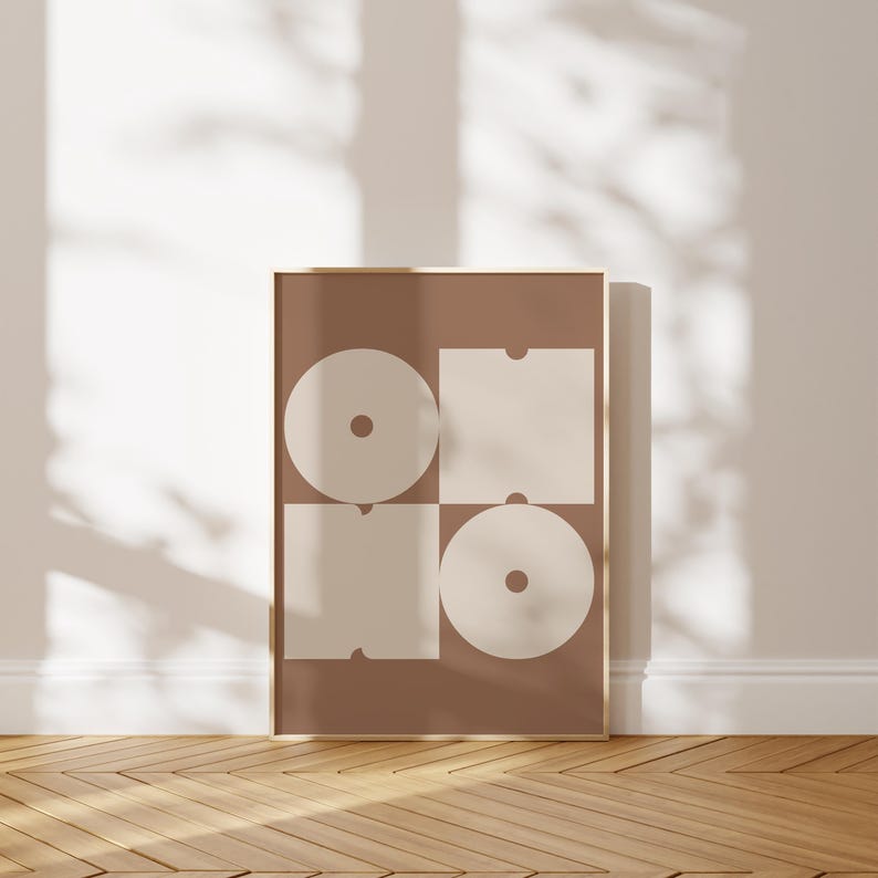 May include: A brown poster with a geometric design featuring four white shapes. The shapes are a circle, a square, and two rectangles. The circle and square have a smaller circle inside them.