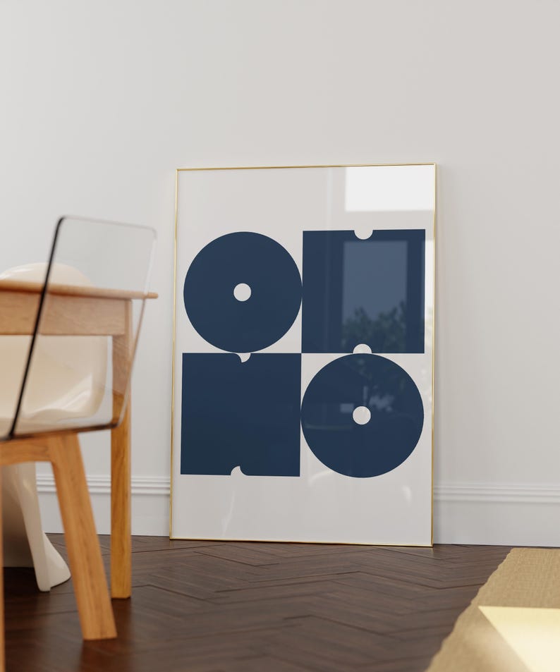 May include: A framed print with a geometric design featuring four navy blue shapes, including circles and squares, on a white background.