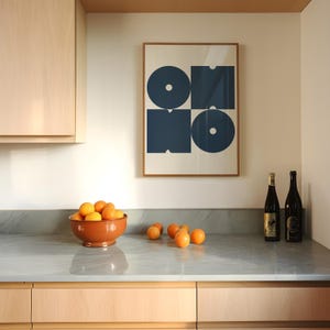 May include: A kitchen counter with a bowl of oranges, two bottles of wine, and a framed print with a blue geometric design. The print has the word "ONO" in a stylized font.