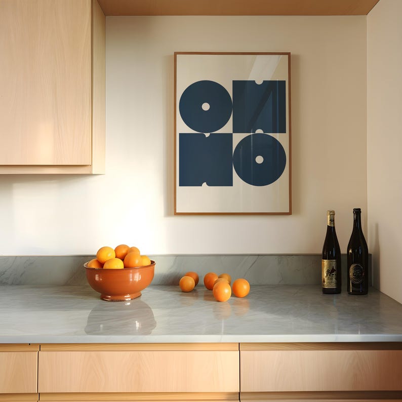 May include: A kitchen counter with a bowl of oranges, two bottles of wine, and a framed print with a blue geometric design. The print has the word "ONO" in a stylized font.
