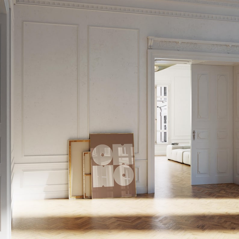 May include: A white room with a wooden floor and a doorway leading to another room. There are two framed pieces of art on the wall, one with a brown background and white text, and the other with a canvas texture.