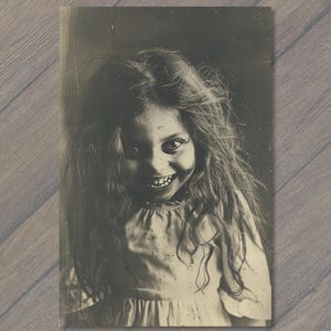 May include: A black and white vintage-style photograph of a child with long, messy hair and a wide, toothy grin. The child wears a simple, light-colored dress with a gathered neckline, captured in a high-contrast, grainy, and aged aesthetic.