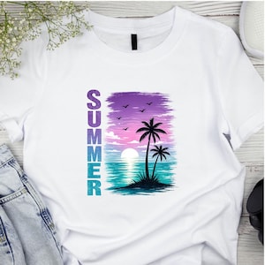 Può includere: T-shirt bianca con grafica colorata di un tramonto tropicale. Il design presenta palme, un sole al tramonto e la parola "SUMMER" in testo verticale. Il cielo passa dal viola al rosa e al blu.