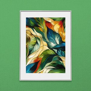 May include: Abstract art print in a silver frame. The artwork features a colorful leaf design with shades of green, blue, yellow, and orange. The leaves have a stained-glass effect, creating a vibrant and eye-catching piece.