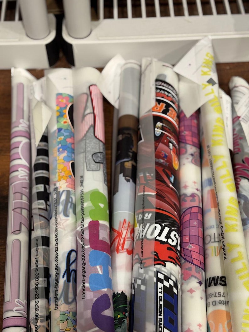 a collection of colorful, patterned rolls of paper or fabric, each with unique designs and text.