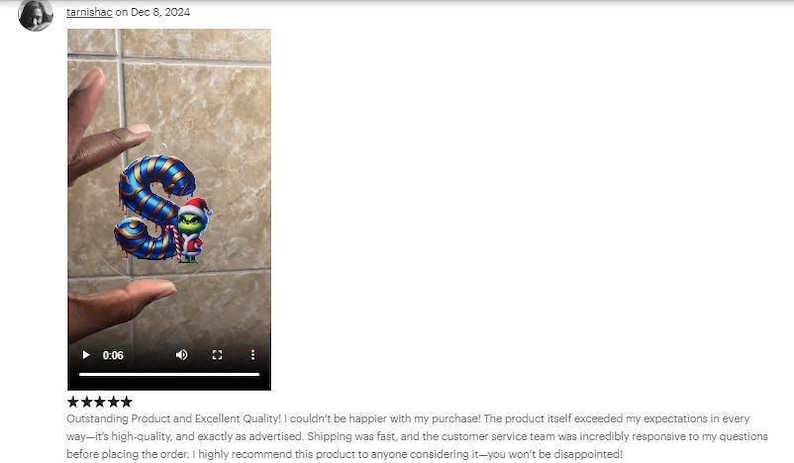 a hand holding a toy in front of a tiled wall