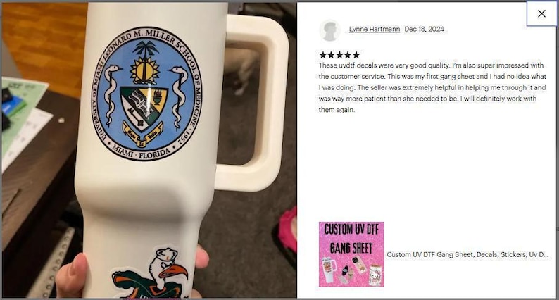 A person is holding a white mug with a blue and green emblem on it, and there is a review of the mug on a website.