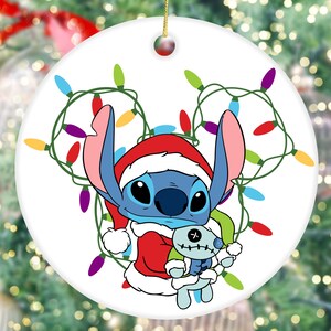 A Christmas ornament featuring a cartoon character wearing a Santa hat and holding a small stuffed animal.