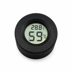 Op de afbeelding: Een ronde zwarte digitale hygrometer en thermometer met een lichtgekleurd rond display. Het scherm toont de temperatuur als 28,8 graden Celsius en de relatieve vochtigheidsgraad als 59 procent in grote zwarte digitale cijfers.