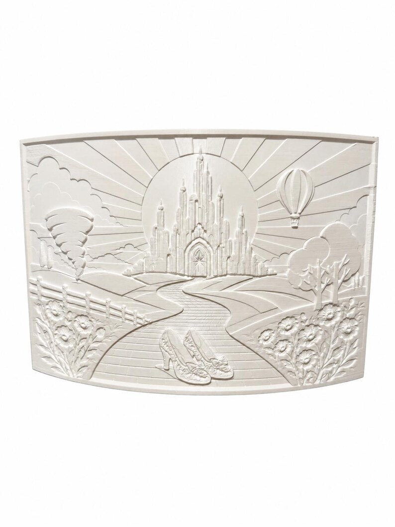 May include: A rectangular off-white wall plaque featuring a relief carving of a fantasy landscape. The scene depicts a central castle, a winding path leading to it, a pair of shoes in the foreground, a tornado on the left, and a hot air balloon.