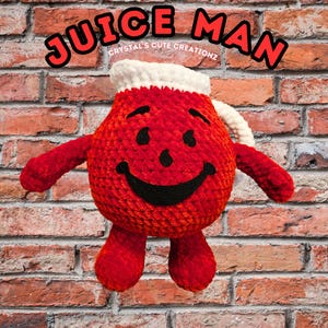 May include: A crocheted plush toy shaped like the iconic Juice Man character. The toy is red with a white rim around the top and a black smiling face. The text "JUICE MAN" is written in red letters above the toy. The text "CRYSTAL'S CUTE CREATIONS" is written in white letters below the toy.