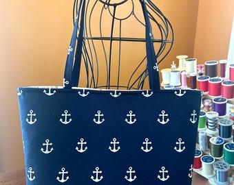 Borsa tote trapuntata a mano con motivo ancore nautiche blu navy, 25x38 cm, 2 tasche interne, chiusura con bottone magnetico.