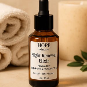 May include: A brown glass bottle of HOPE skincare Night Renewal Elixir with a black dropper. The label reads "Powered by 1% Bakuchiol & 10% Vitamin C THD". The bottle contains 1 oz / 30 mL of product. A rolled white towel and a candle are in the background.