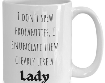 May include: White ceramic coffee mug with black text that reads "I don't spew profanities, I enunciate them clearly like a Lady".
