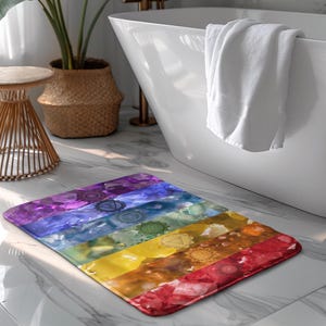 May include: A colorful bath mat with a rainbow design featuring seven chakra symbols. The mat is made of soft, absorbent material and is perfect for adding a touch of color and spirituality to your bathroom.