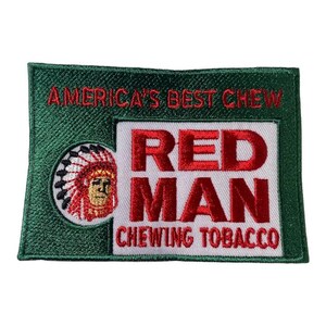 Può includere: Una toppa ricamata verde e bianca con il testo "America's Best Chew Red Man Chewing Tobacco" e un'immagine di un nativo americano con un copricapo.
