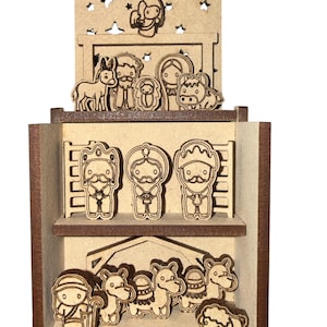 Puede incluir: Un nacimiento de madera de tres niveles con figuras cortadas a láser de la sagrada familia, los tres reyes magos, animales y un pastor. El panel superior tiene grabado el texto Feliz Navidad y estrellas recortadas en madera clara.