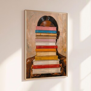 Puede incluir: Una impresi&oacute;n art&iacute;stica enmarcada que representa a una persona sosteniendo una pila de libros coloridos frente a su rostro. Los libros tienen lomos de varios colores, incluyendo rojo, amarillo, azul y rosa. La obra de arte tiene un fondo c&aacute;lido y neutro.