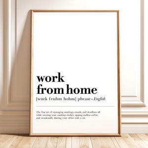 Peut inclure: Une affiche encadrée avec l'expression "work from home" en gras noir. En dessous, une définition et une description du style de vie du travail à domicile sont fournies. Le cadre est de couleur marron clair.